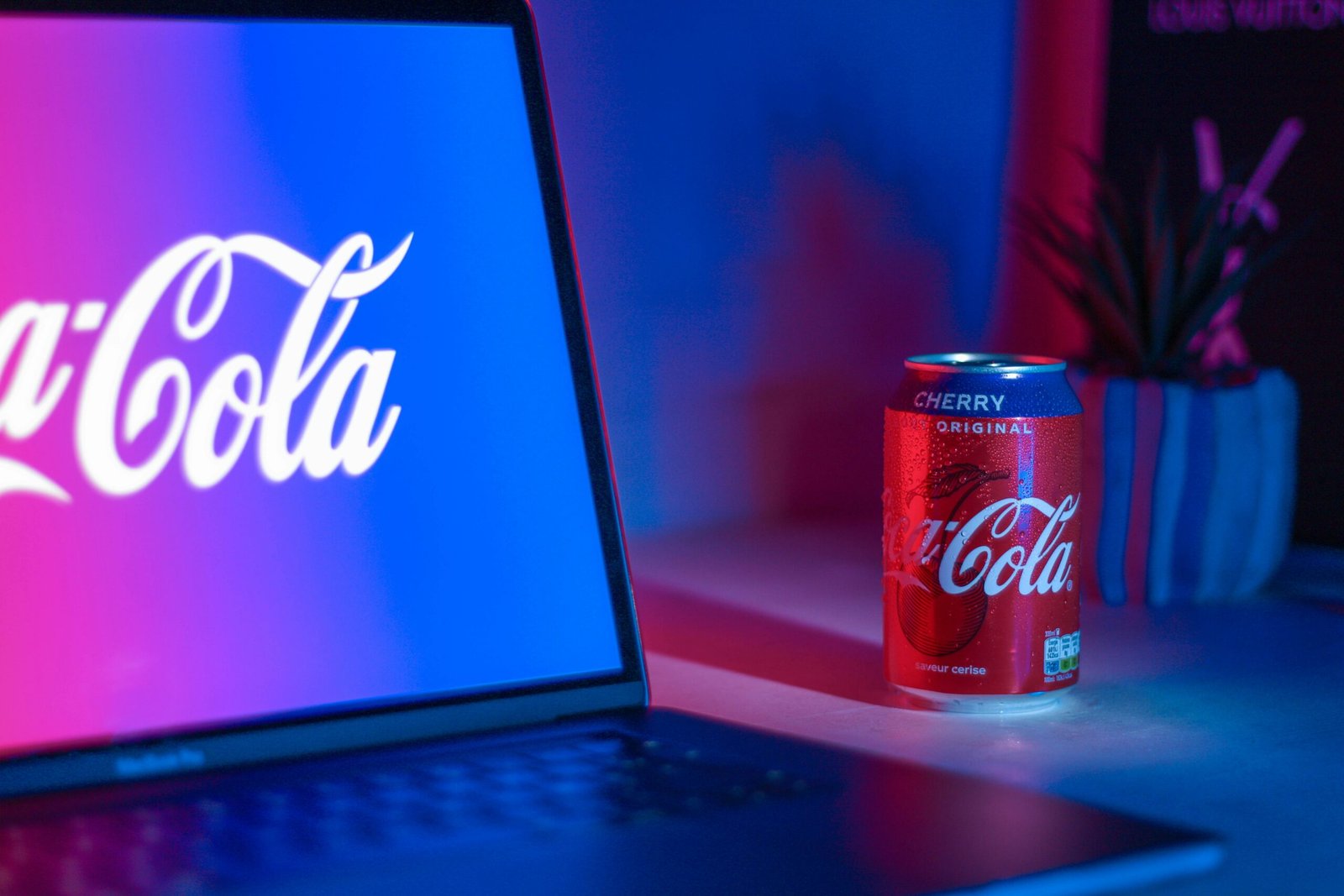 Coca-Cola soda can beside laptop